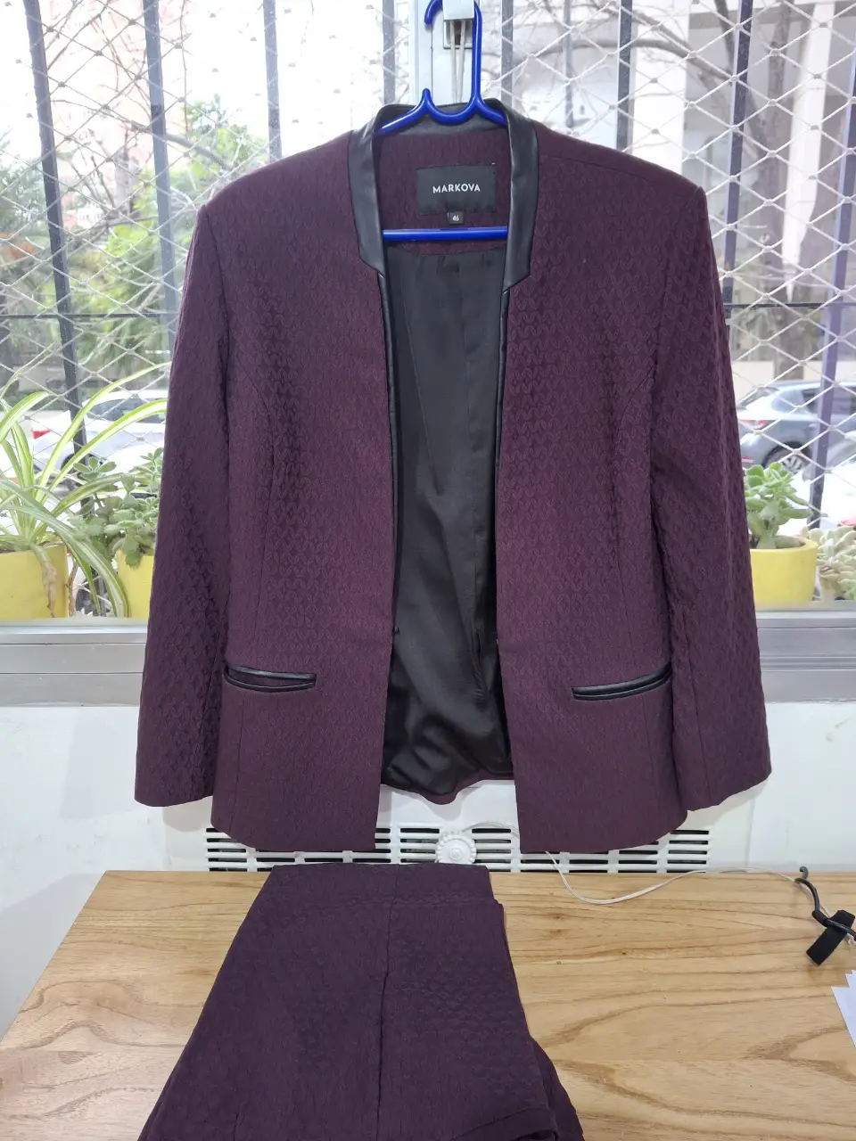 Traje de blazer y pantalón sastrero de Markova, color borravino con detalles en negro. Blazer con solapa y bolsillos, pantalón a juego.