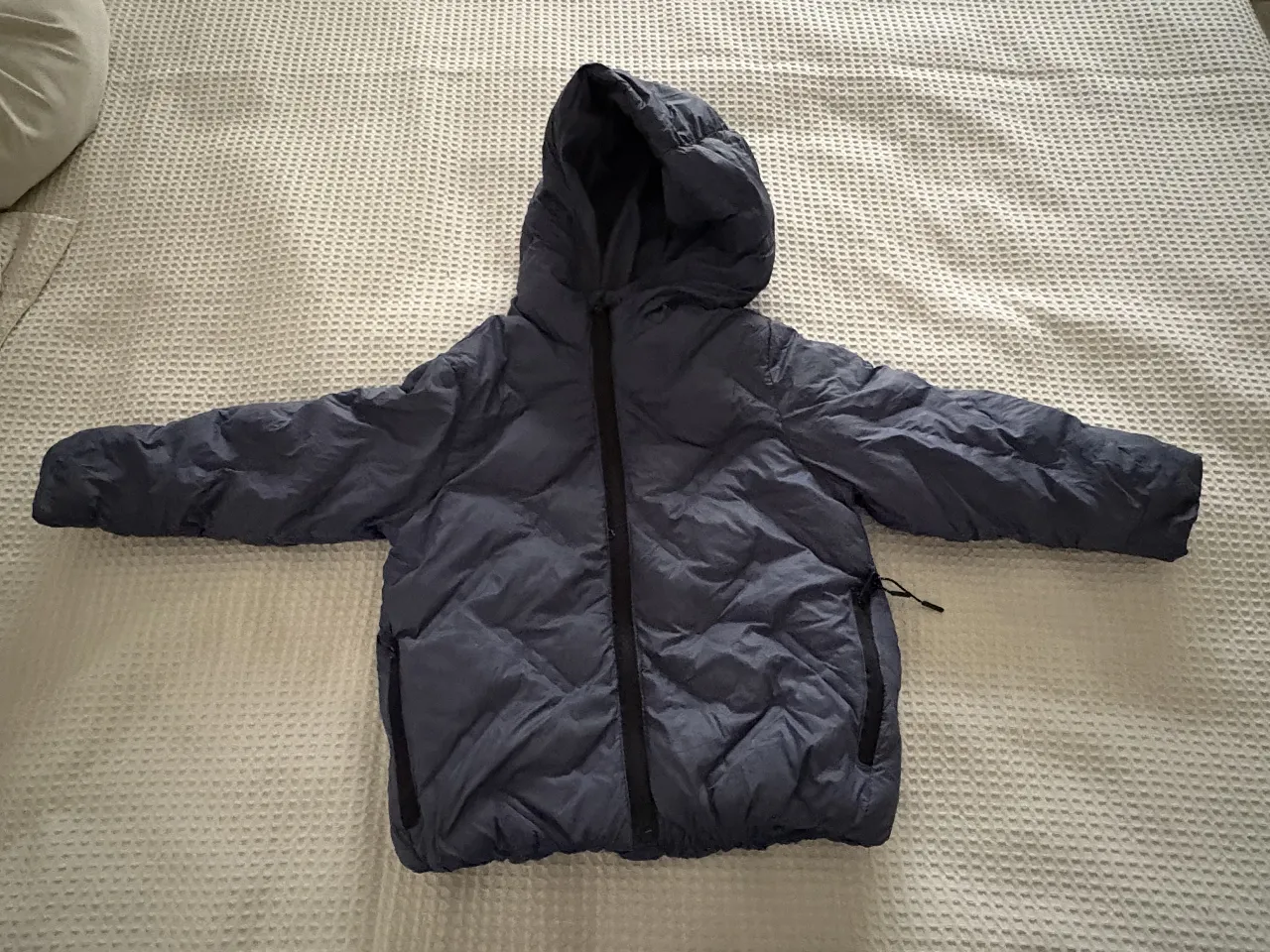 Campera de pluma azul para niño/a, con capucha y cierre. Ideal para el invierno.