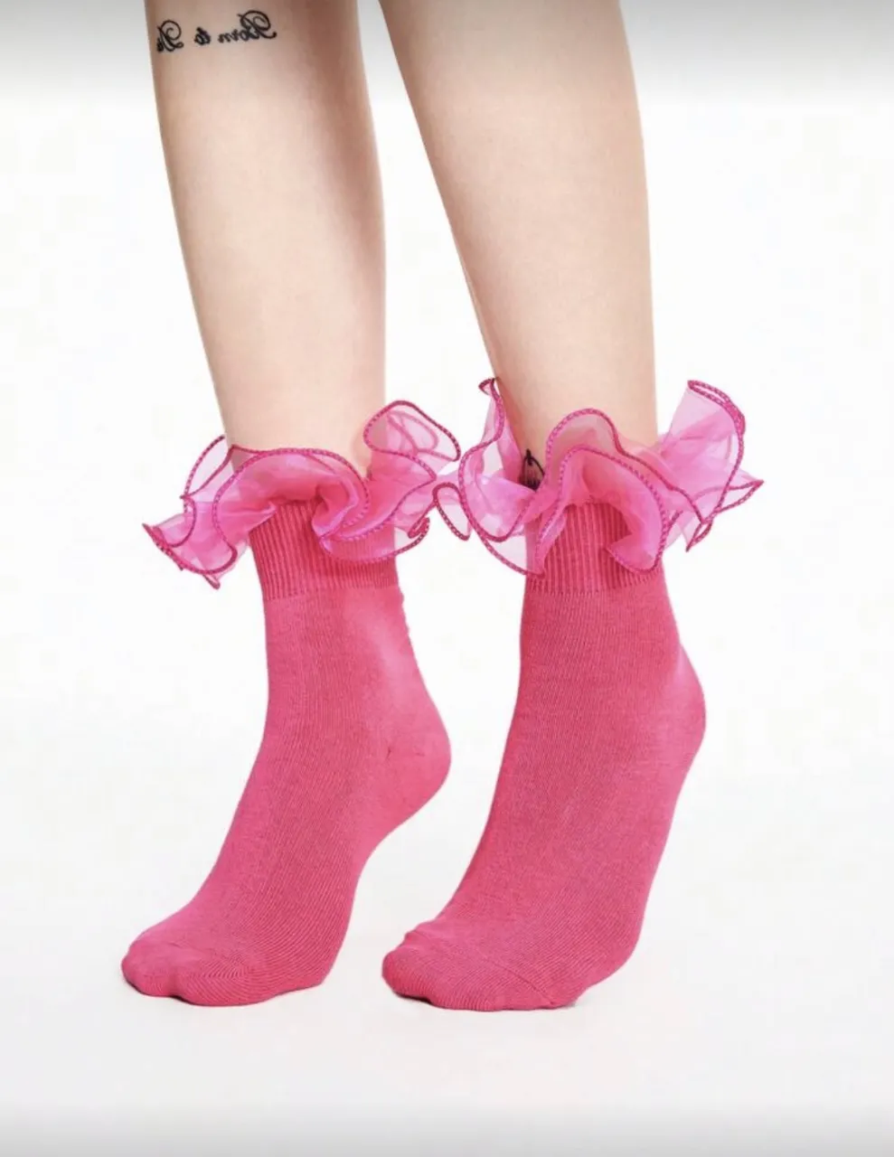 Medias de algodón rosas con volados de tul en el borde superior.