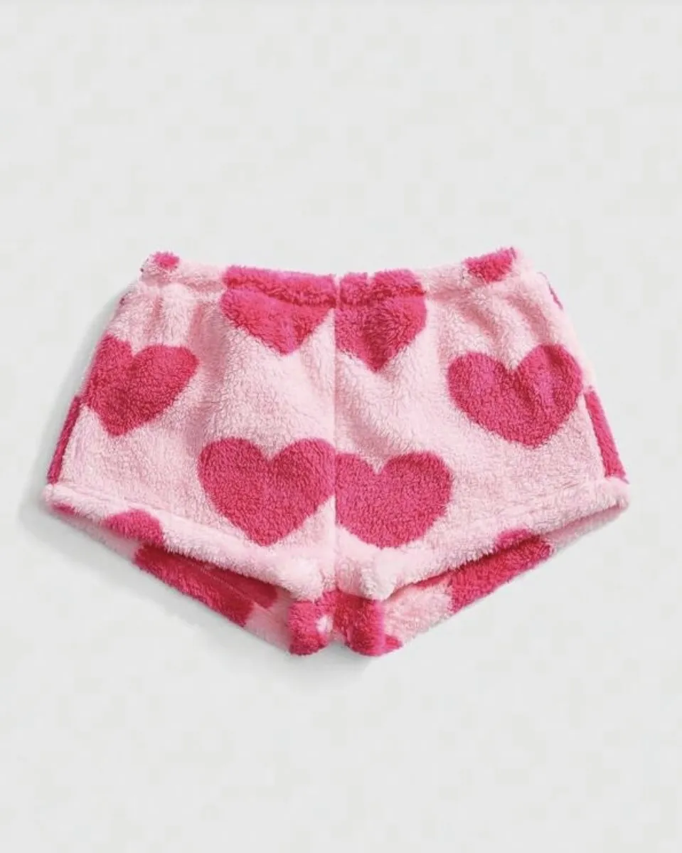 Shorts de plush rosa con estampa de corazones fucsia.