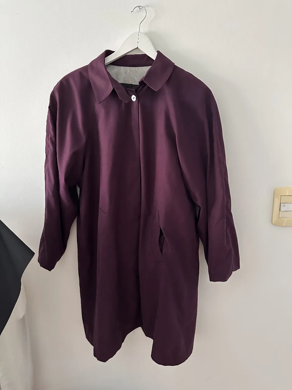 Trench coat de color borgoña, ideal para el invierno. Posee un corte clásico y elegante, con un solo botón y bolsillos laterales. Perfecto para un look sofisticado y abrigado.