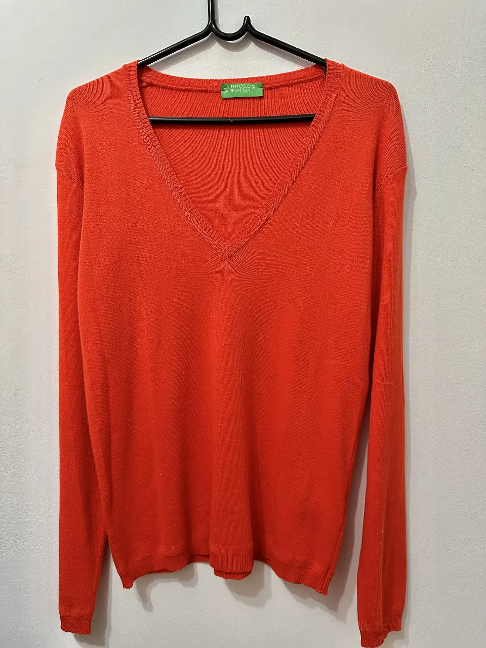 Sweater en V de color naranja, ideal para un look casual y cómodo. Perfecto para usar en otoño o invierno.
