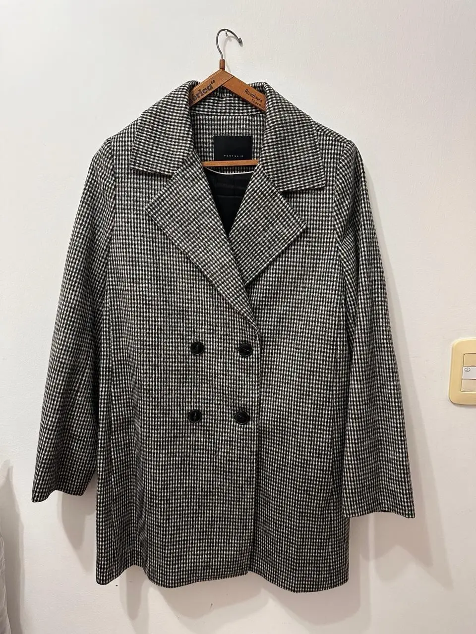 Tapado Ports & Said de paño con estampado de cuadros en blanco y negro. Corte clásico con solapas, cierre de botones y forro interior negro. Ideal para un look elegante y abrigado.