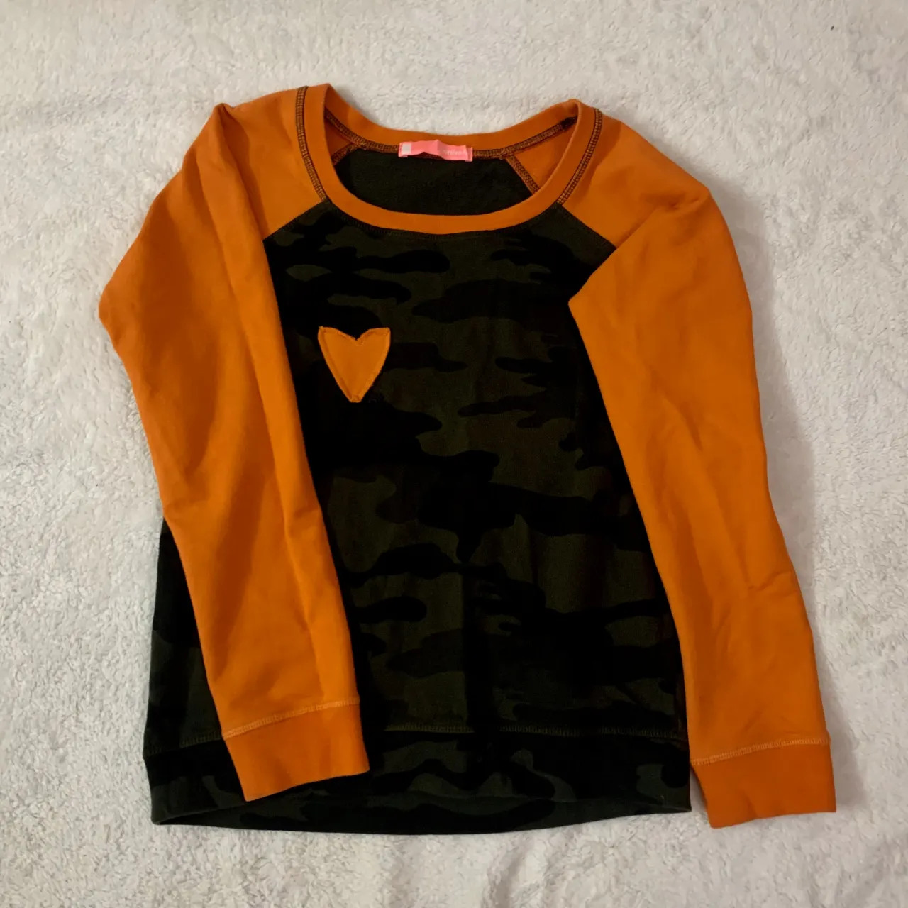 Camiseta/Buzo vintage 2000s! impecable!
Remera manga larga con estampa camuflada en el frente y mangas lisas color naranja. Detalle de corazón naranja aplicado en el frente. Cuello redondo y puños naranjas.
