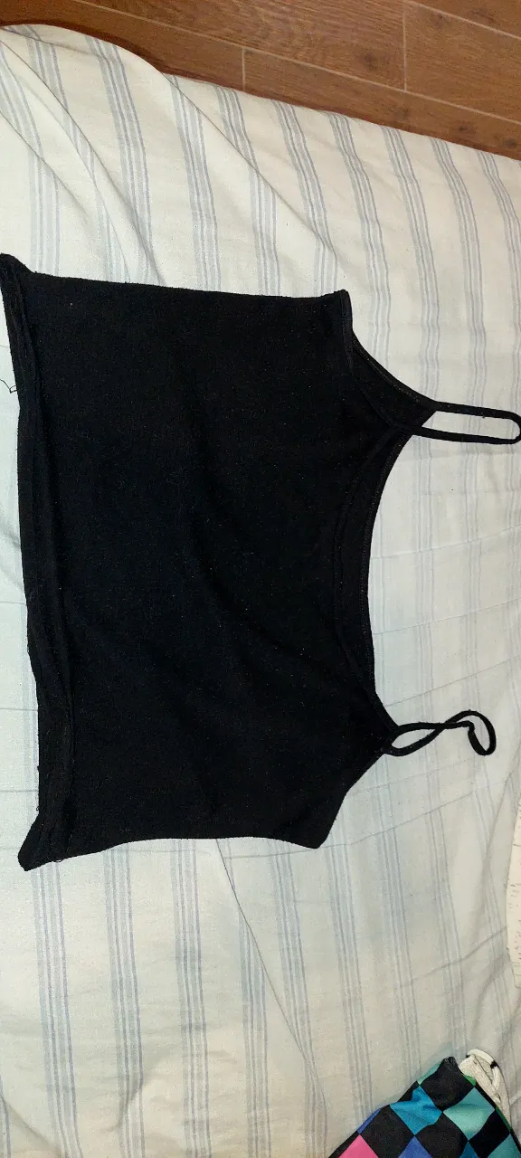 Musculosa negra básica, ideal para el día a día o para combinar con otras prendas. Su diseño simple y corte cómodo la hacen perfecta para cualquier ocasión.