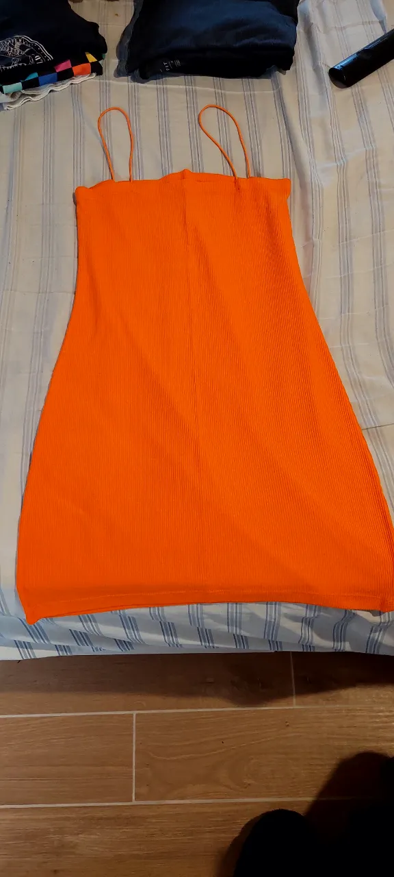 Vestido naranja vibrante, ideal para el verano. Su diseño de tirantes finos y tela acanalada lo hacen súper cómodo y canchero. Perfecto para lucir en la playa o en una salida informal.