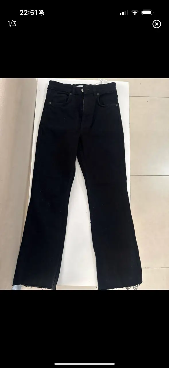 Jeans negro de corte recto con terminación desflecada. Tiro alto. Marca Zara.