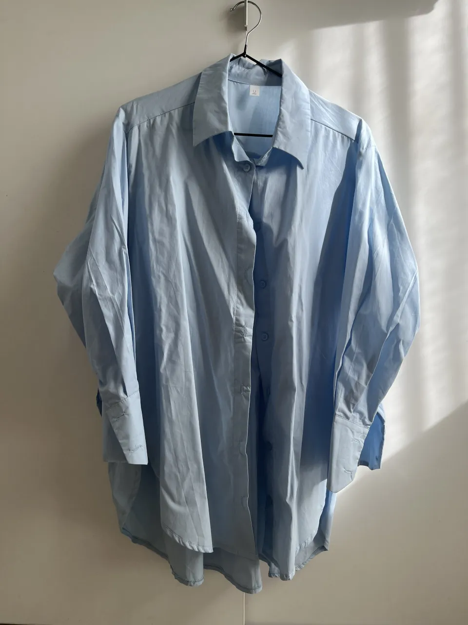 Camisa oversize celeste de corte clásico, ideal para un look casual y moderno. Su diseño amplio la hace súper cómoda y versátil, perfecta para combinar con jeans o pantalones de lino. Un básico infaltable para cualquier guardarropa.

Las últimas 2 fotos son como referencia. Mismo modelo en blanco