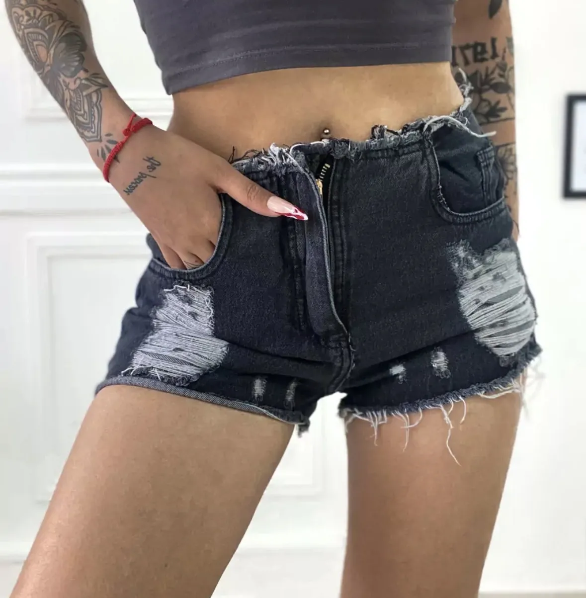 Shorts de jean tiro medio, con roturas y detalles desflecados en los bordes. Un básico canchero para armar looks informales y modernos.