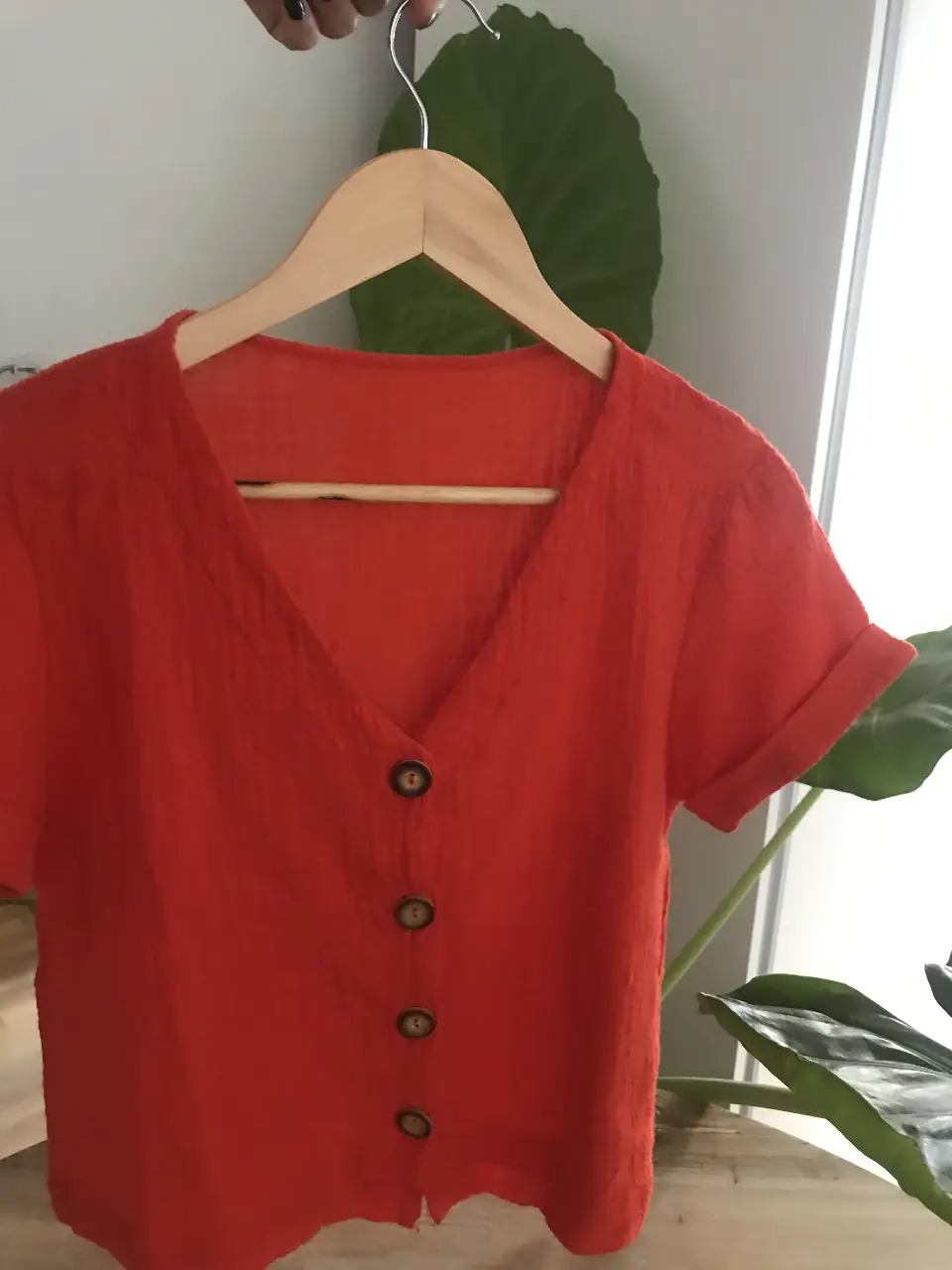 Blusa de mujer en color naranja, con cuello en V y botones frontales. Ideal para un look casual y fresco.