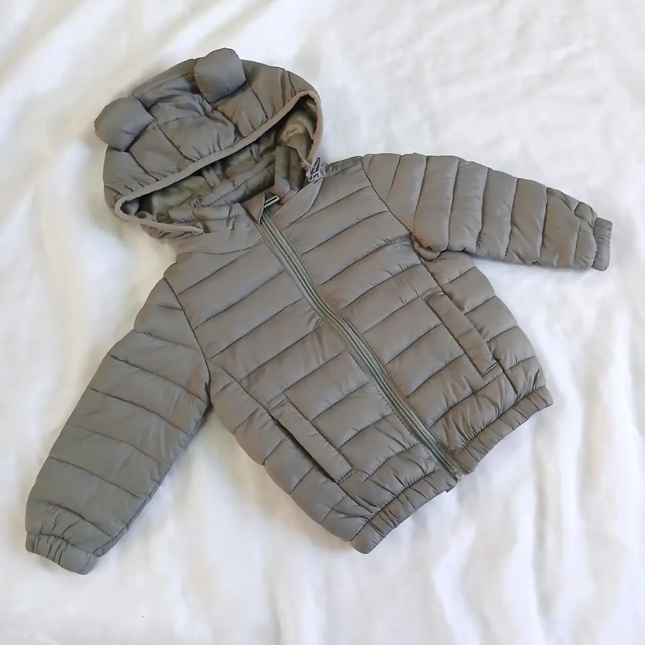 Campera acolchada gris con capucha y orejitas de oso. Ideal para los días fríos, súper abrigada y canchera.