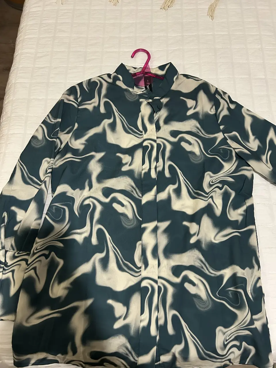 Camisa FUEZAI estampada con diseño de remolino en tonos verde oscuro y blanco. Corte clásico con cuello camisero y cierre frontal con botones. Ideal para un look moderno y sofisticado.