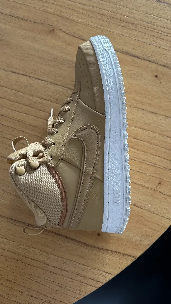Zapatillas Nike Air Force 1 de caña alta en color marrón. Diseño clásico y versátil, ideales para un look urbano y cómodo. Suela resistente y detalles icónicos de la marca.