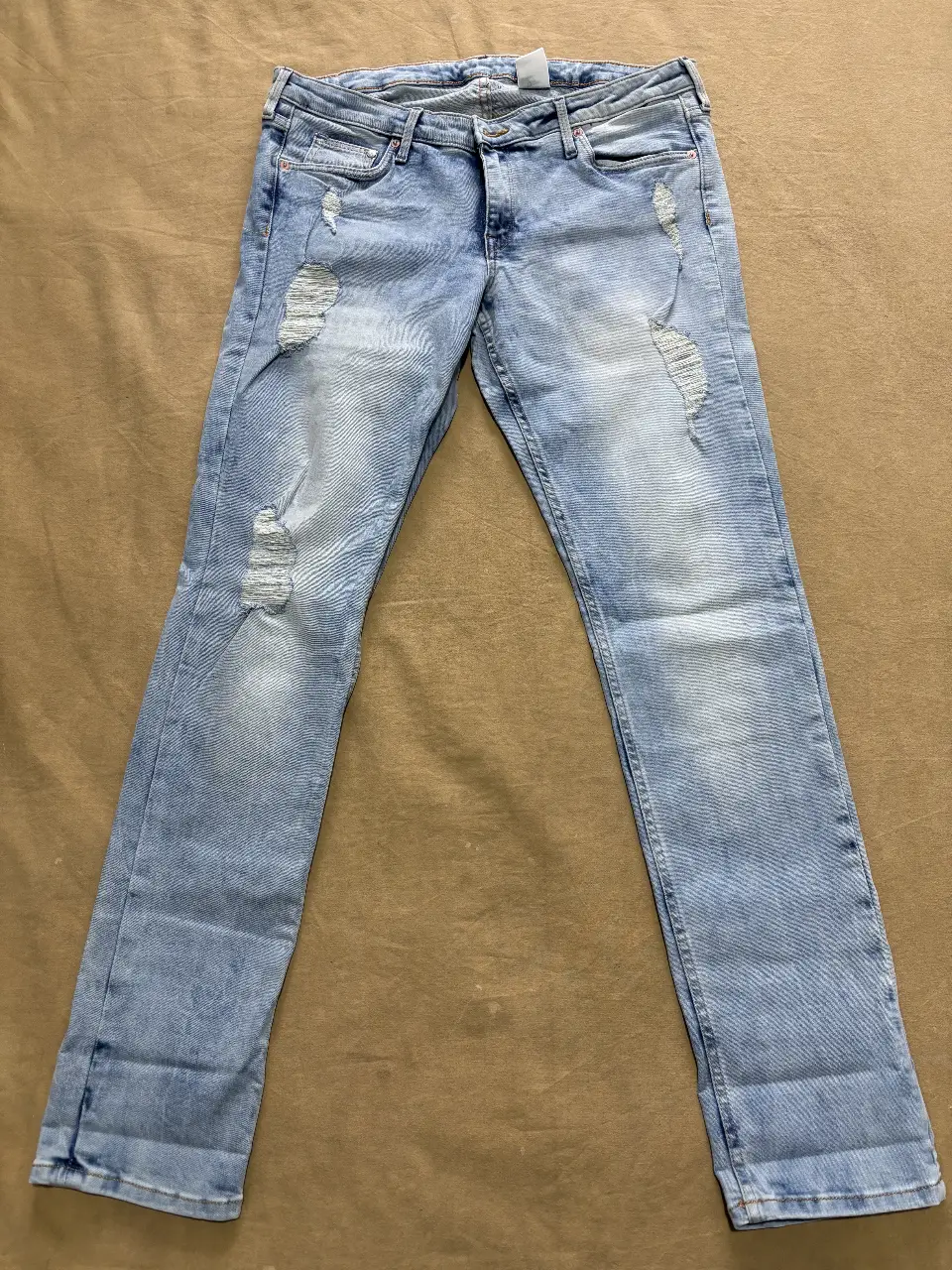 Jeans Skinny de mujer, tiro bajo, con roturas y efecto gastado. Talle 34/32, de la marca H&M.