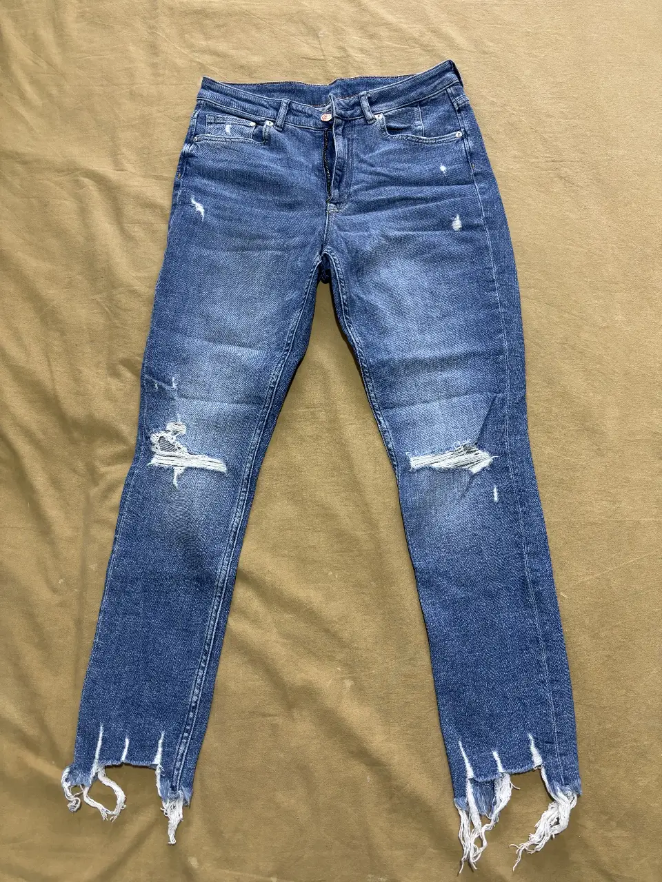 Jeans Skinny de mujer, tiro alto, con roturas en las rodillas y flecos en los bajos. Talle 32.