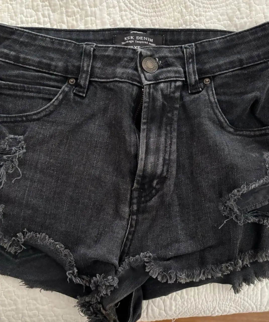 Short de jean negro con detalles rotos y desflecado. Talle XS/38. Ideal para un look casual y canchero.
