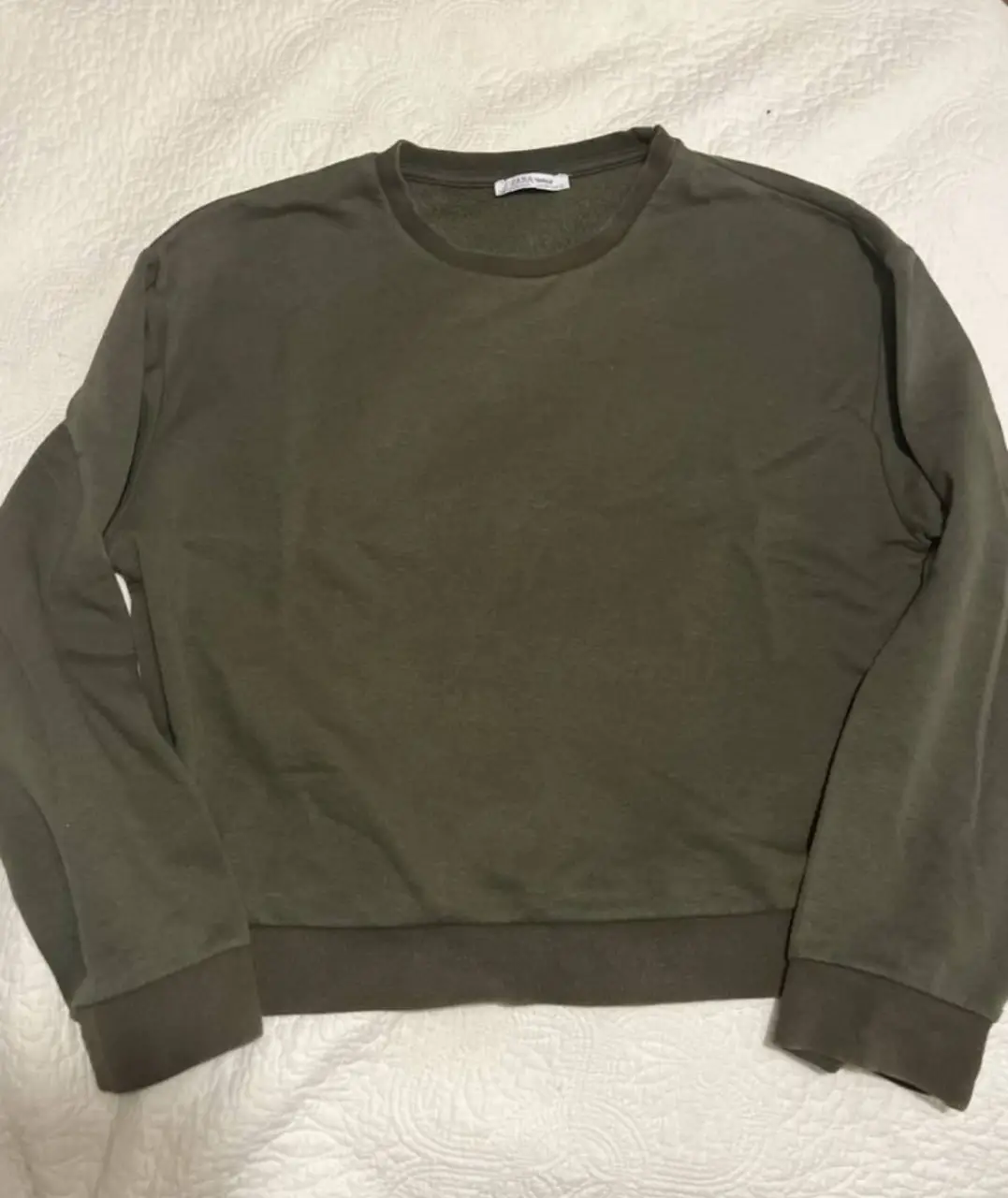 Buzo de cuello redondo en color verde oscuro, ideal para un look casual y cómodo. Perfecto para el día a día.