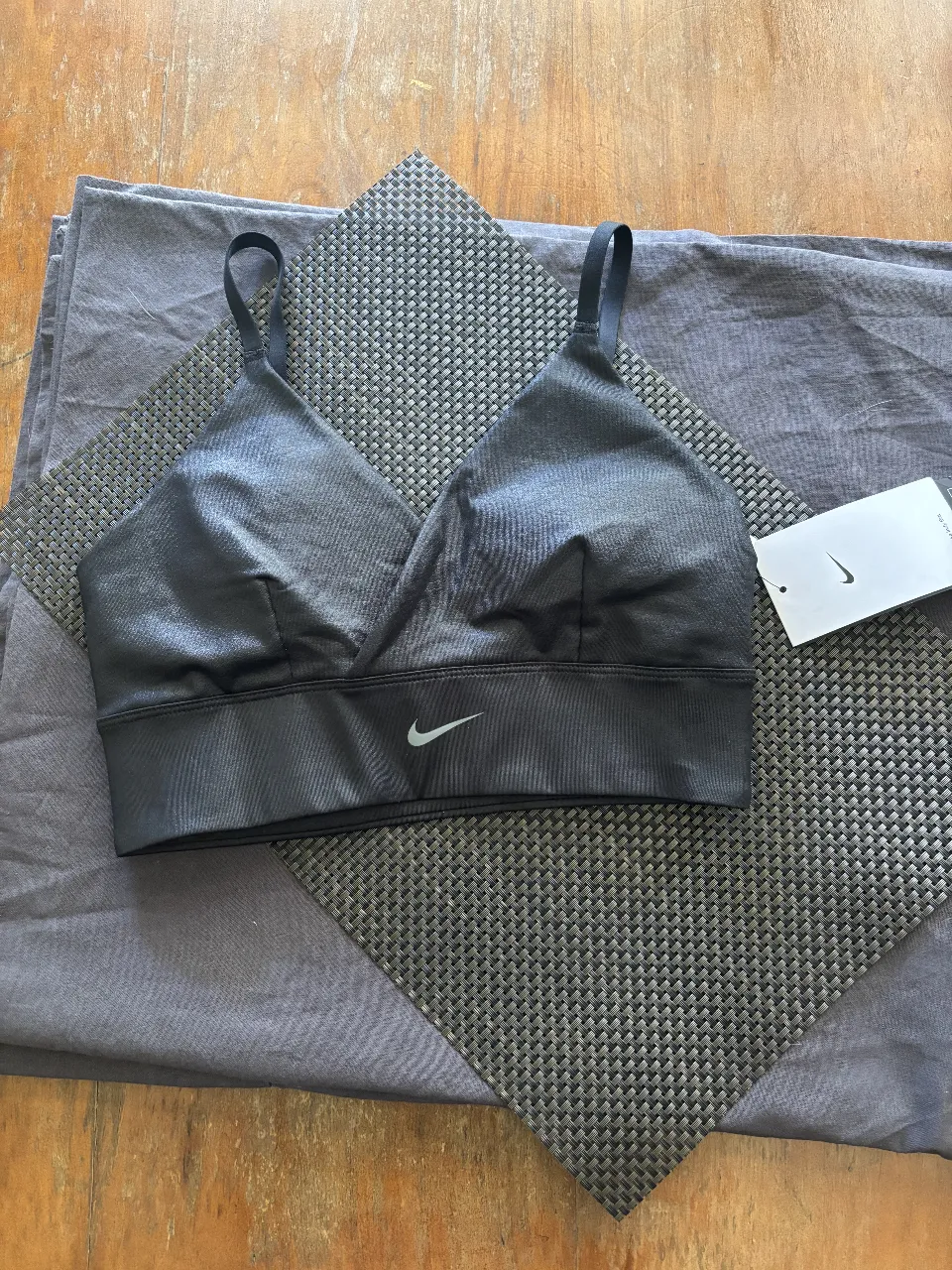 Corpiño deportivo Nike negro con tiras regulables y banda elástica ancha en la cintura.