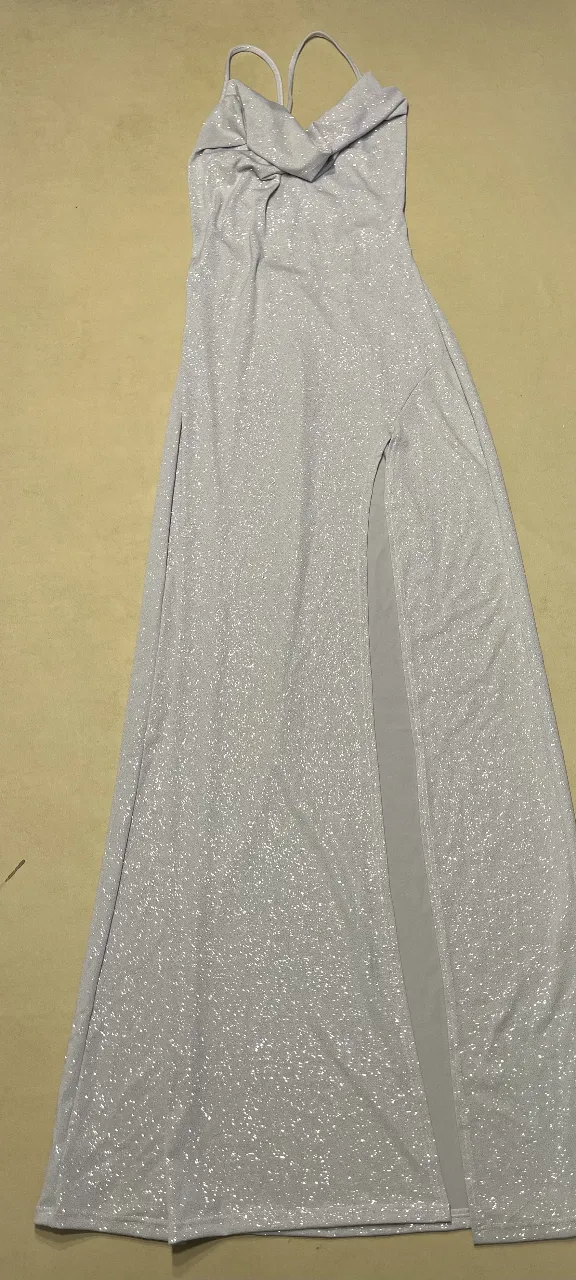 Vestido largo de fiesta para mujer, con diseño elegante y abertura lateral. Ideal para eventos especiales. Color gris plata con detalles brillantes.