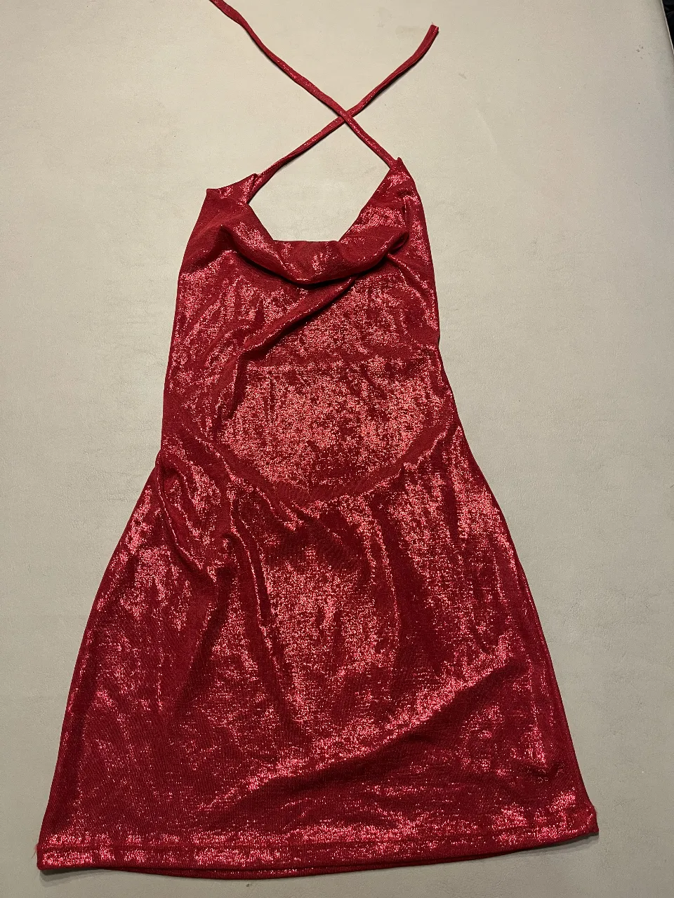 Vestido mini rojo con diseño brillante, ideal para fiestas y eventos especiales. Corte halter con espalda descubierta, perfecto para un look audaz y moderno.