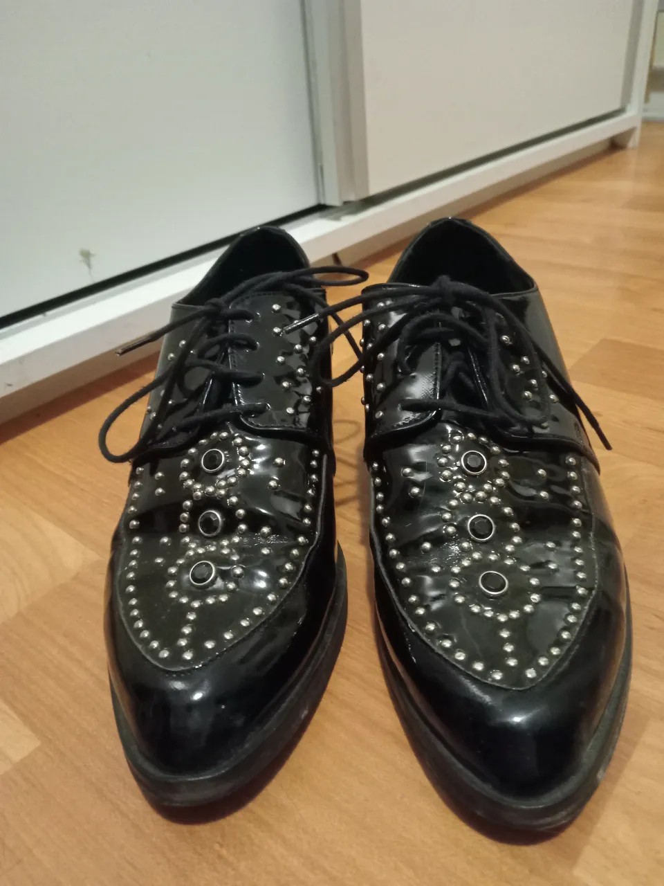 Zapatos negros estilo Oxford con tachas plateadas y punta fina. Perfectos para un look rocker o alternativo.