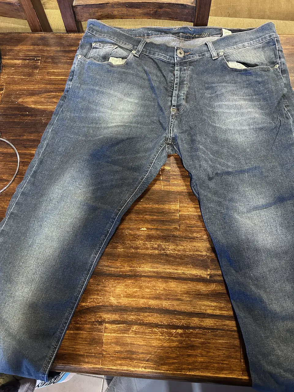 Jeans de hombre, color azul gastado, talle 38. Corte recto, con detalles de desgaste y etiqueta de la marca Bolivia en la parte trasera.