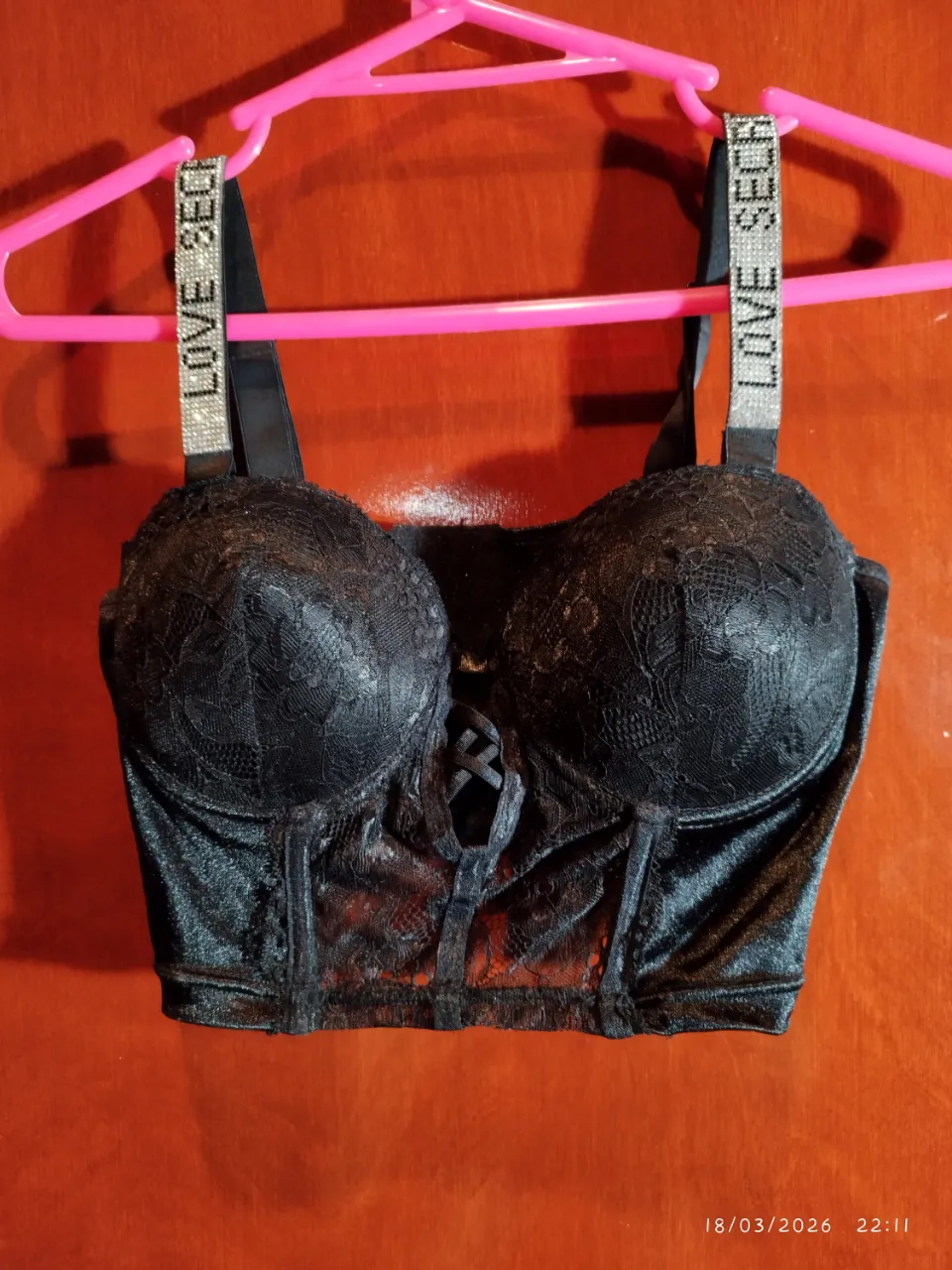 Corpiño negro de encaje con tiras de strass. Posee un detalle de lazo cruzado en el frente.