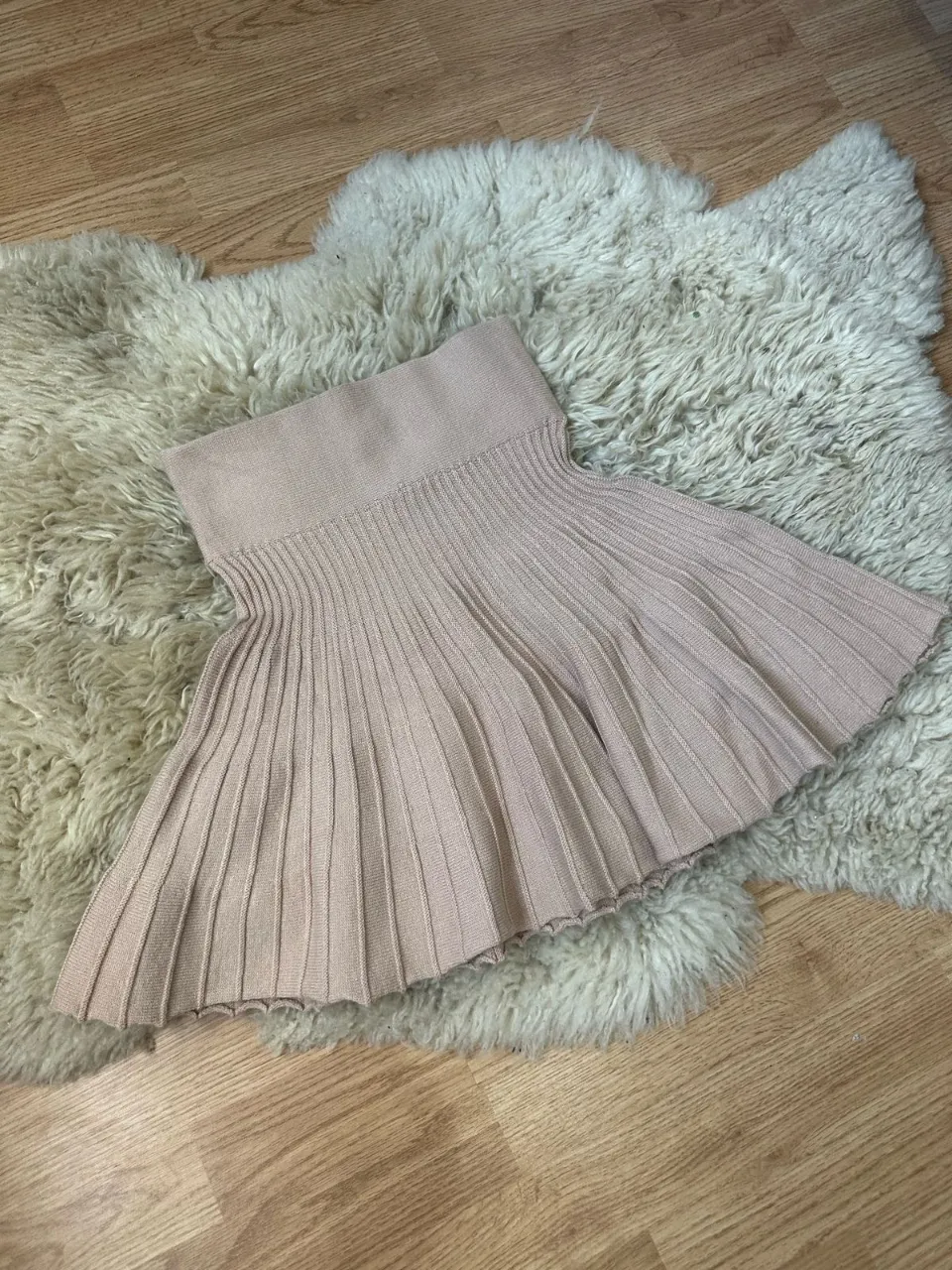 Pollera tejida color tiza con cintura elastizada y falda plisada.