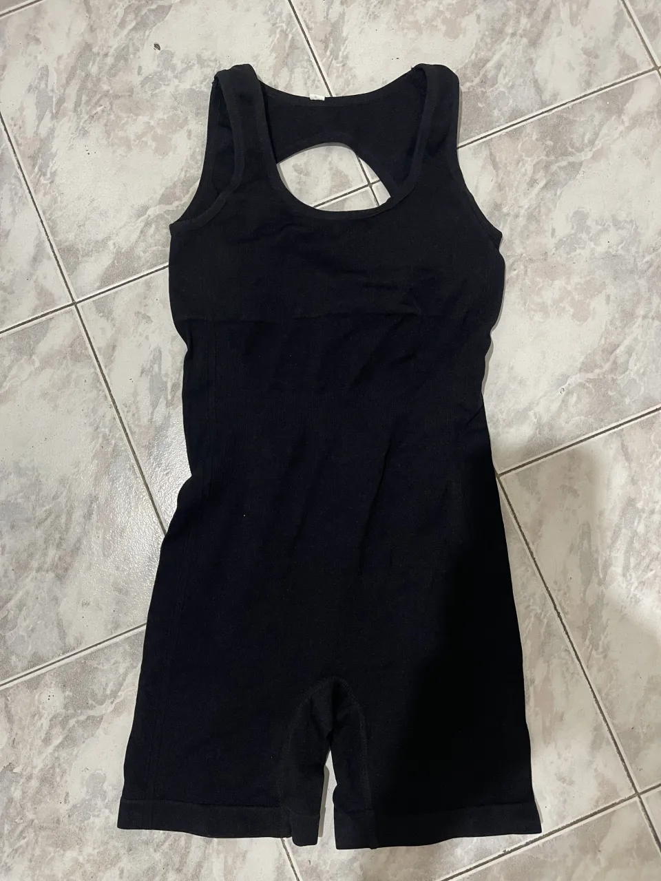 Mono deportivo negro, sin mangas, con recorte circular en la espalda. super elastizado abarca hasta un L. reduce talles ideal para entrenar 