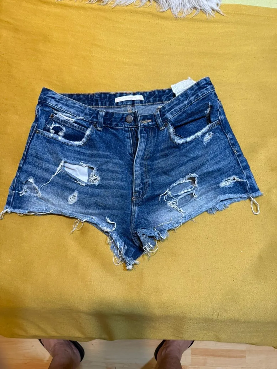 Shorts de jean azules con roturas y detalles deshilachados en los bordes.