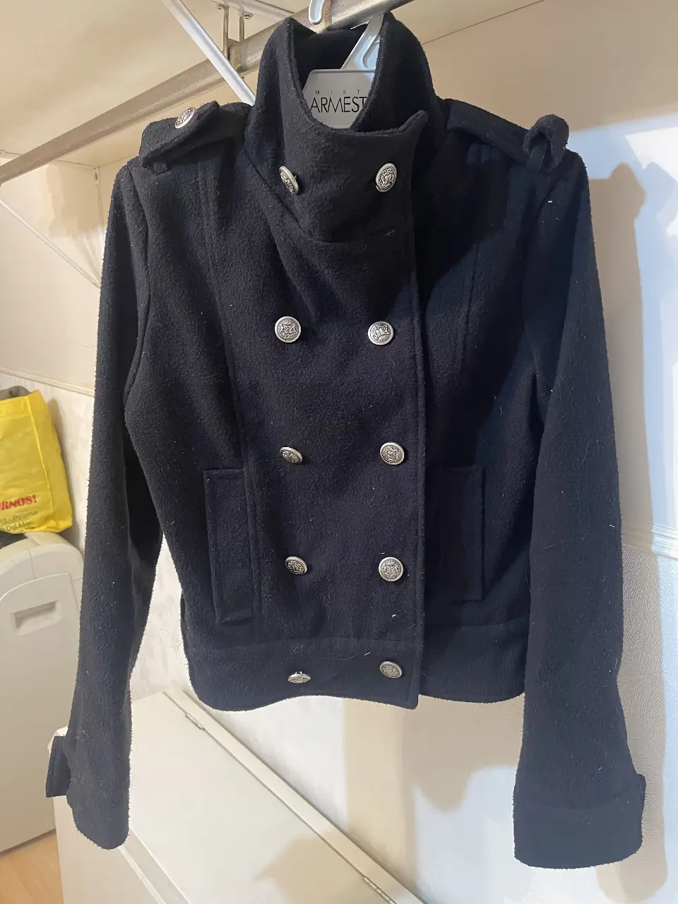 Campera negra estilo militar, con botones plateados y detalles en los hombros. Ideal para un look elegante y moderno.