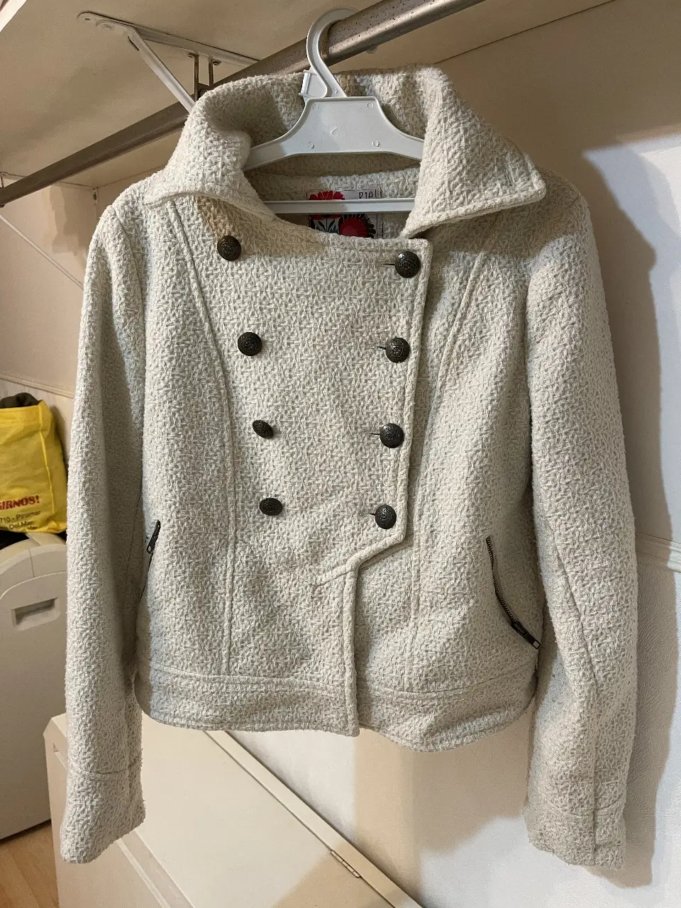 Campera de mujer en color crudo, con diseño de botones y cuello solapa. Ideal para un look casual y abrigado.