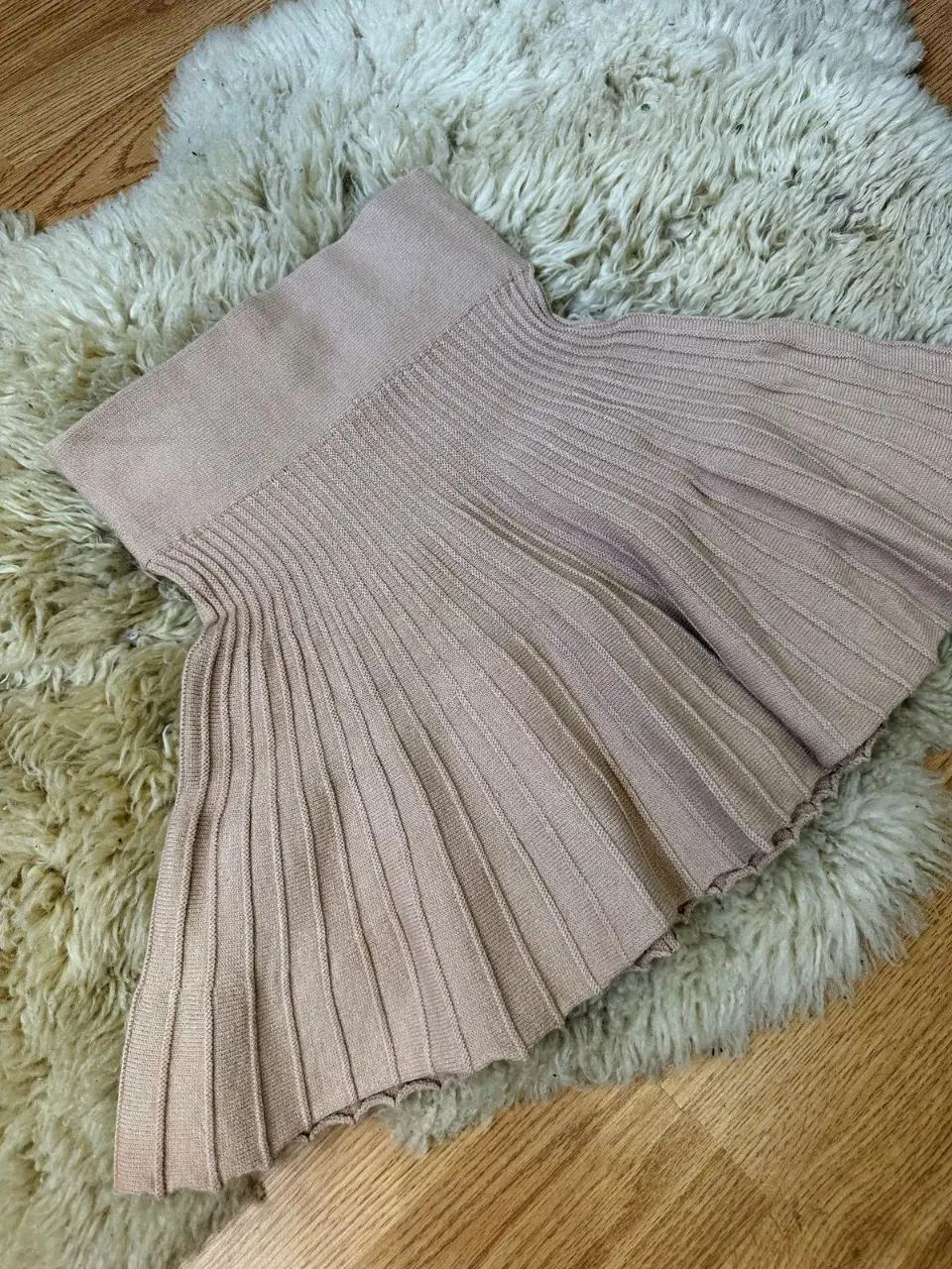 Pollera de tejido plisado en color rosa, ideal para un look elegante y moderno. Perfecta para combinar con diferentes tops y crear outfits versátiles.