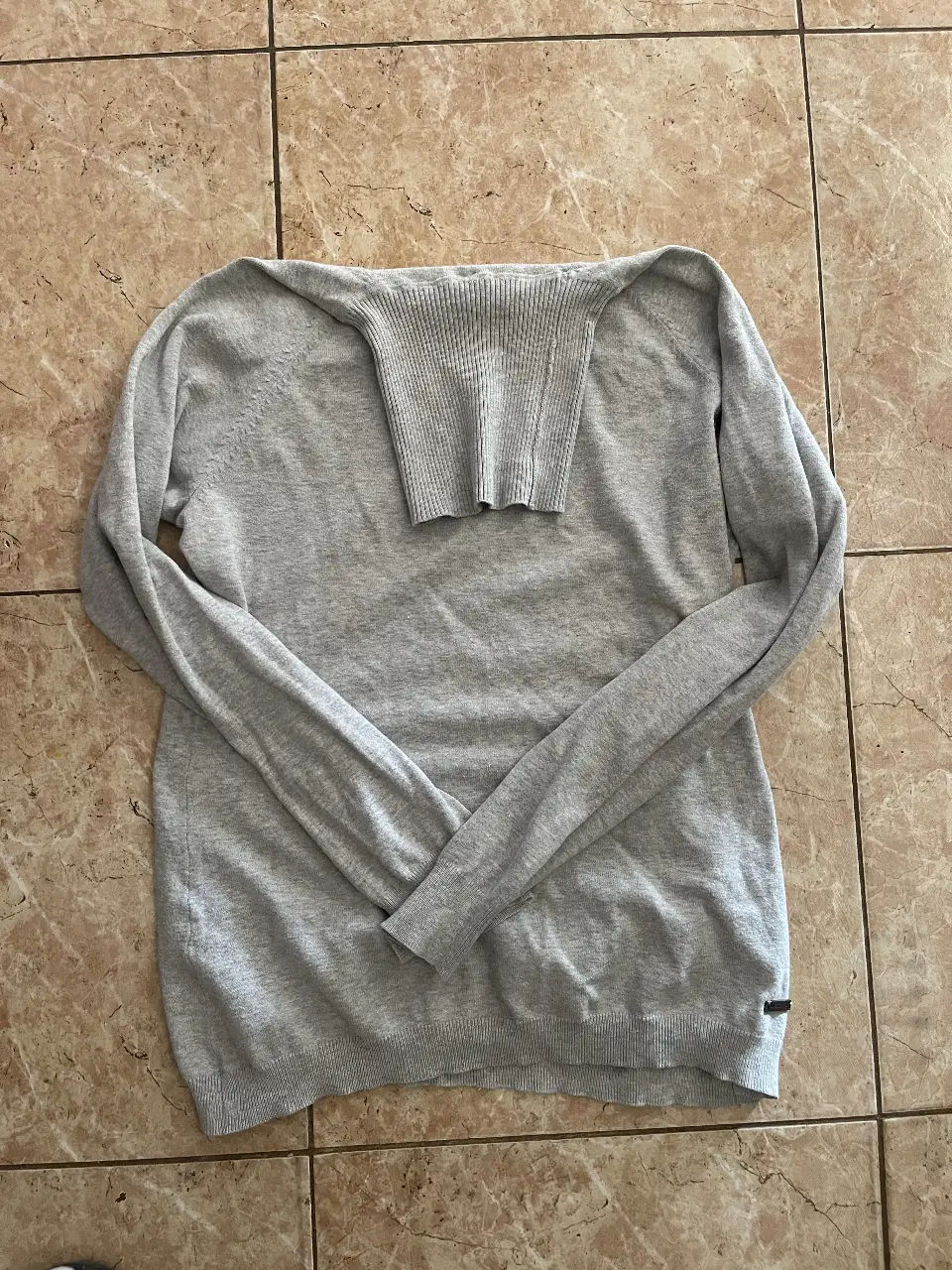 Sweater largo de mujer, color gris, con cuello alto y mangas largas. Ideal para un look casual y abrigado.
