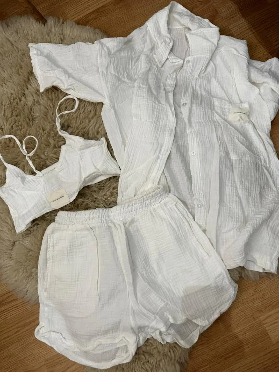 Conjunto de lino blanco, ideal para el verano. Incluye top, camisa y short, perfecto para un look casual y cómodo.