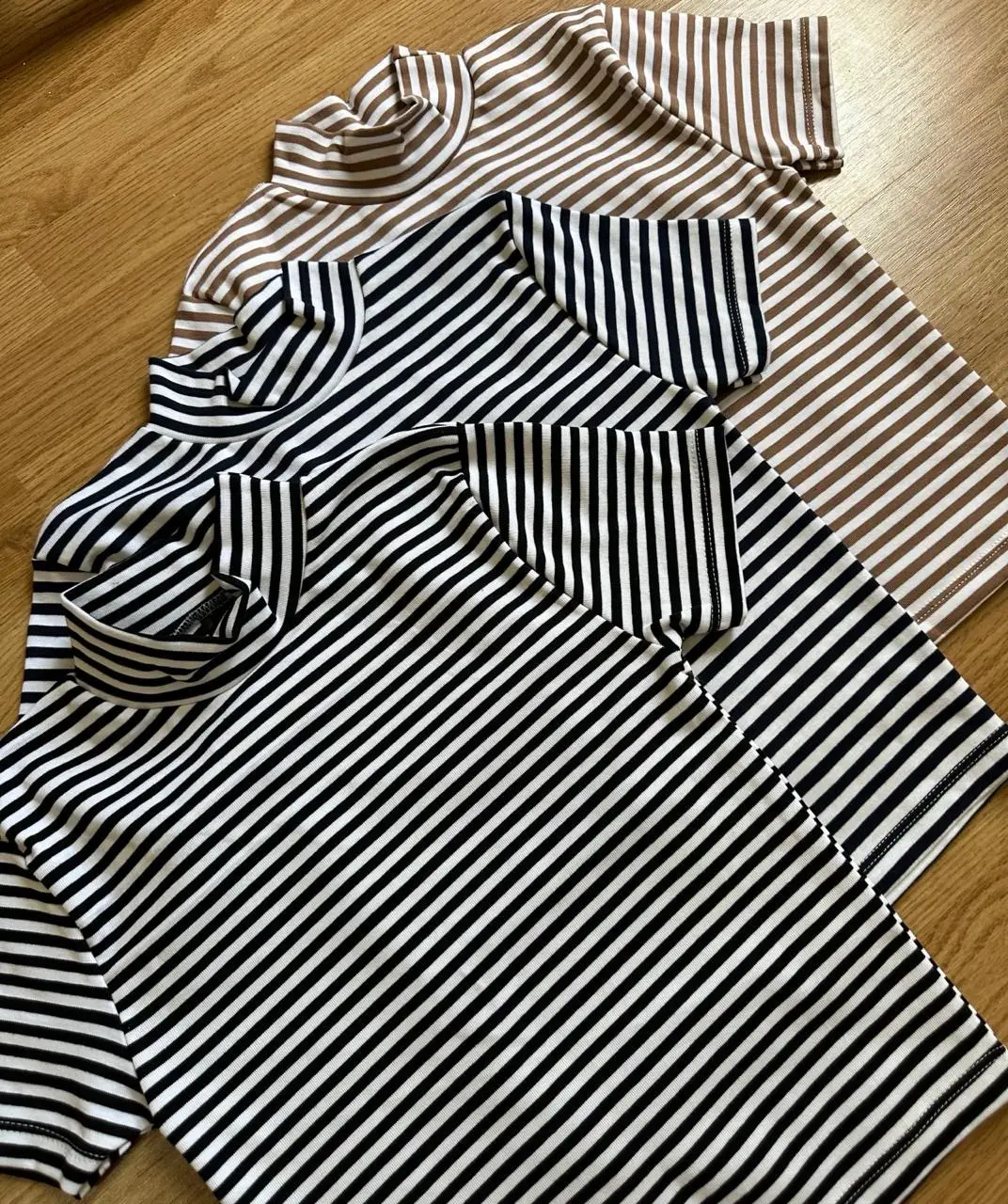 Remera de cuello alto a rayas blancas y azul oscuro, ideal para un look casual y moderno. Perfecta para combinar con jeans o pantalones de vestir. también disponible en beige y blanco 
