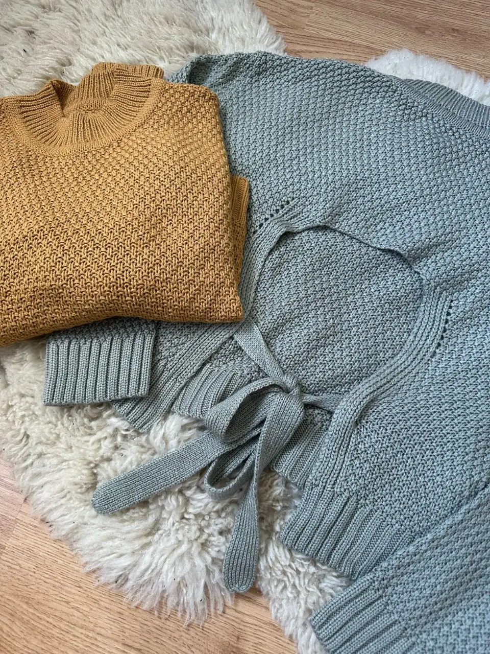 Conjunto de sweaters tejidos, uno en color mostaza y otro celeste con diseño de espalda abierta y lazos. Ideal para un look casual y abrigado.