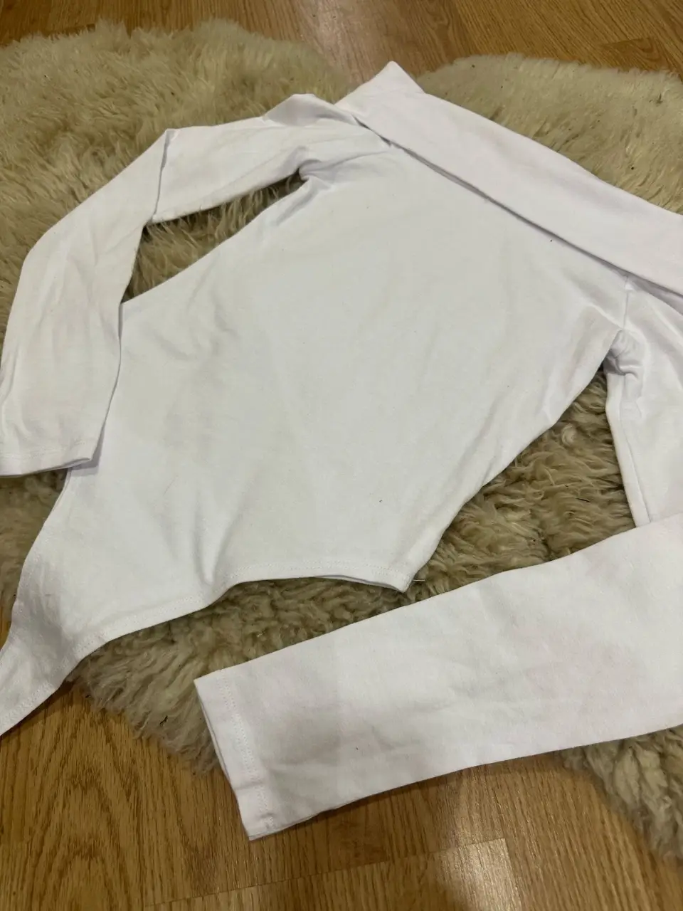 Body blanco de manga larga y cuello alto, ideal para un look elegante y versátil. Perfecto para combinar con jeans o faldas.