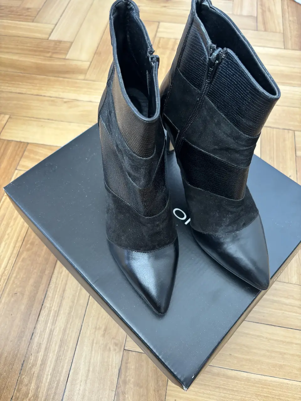 Botines de mujer negros con detalles en diferentes texturas, ideales para un look elegante y sofisticado. Diseño con punta fina y taco alto.