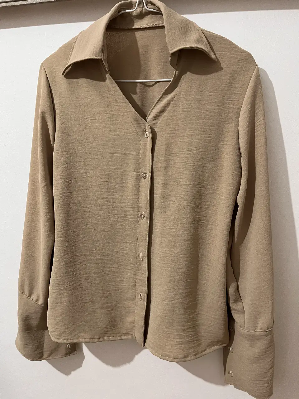 Camisa color crudo con cuello camisero y botones. Ideal para un look elegante y versátil.