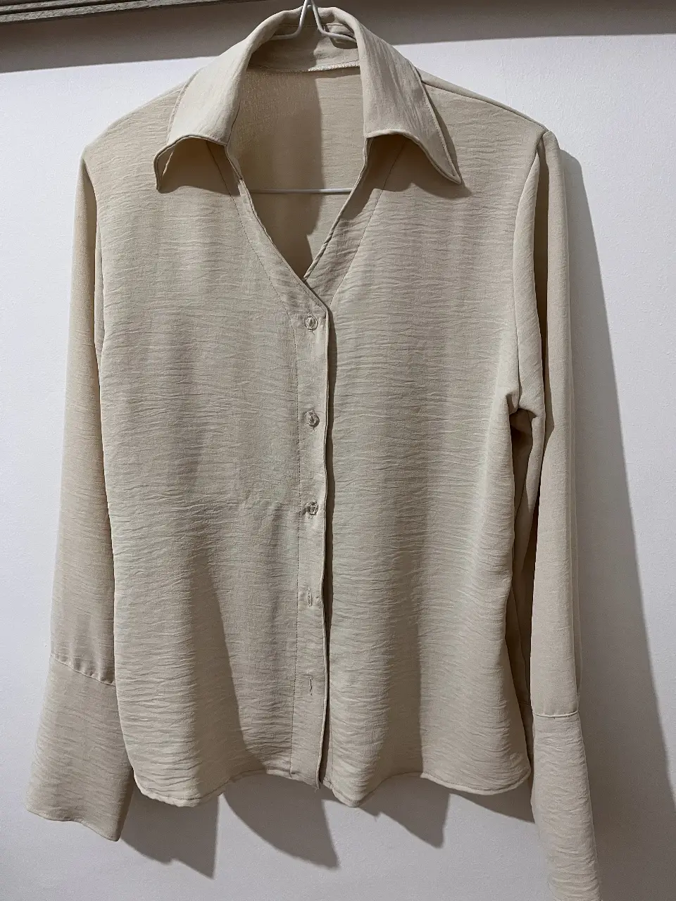 Canisa en color crudo, con cuello camisero y botones frontales. Ideal para un look elegante y versátil.