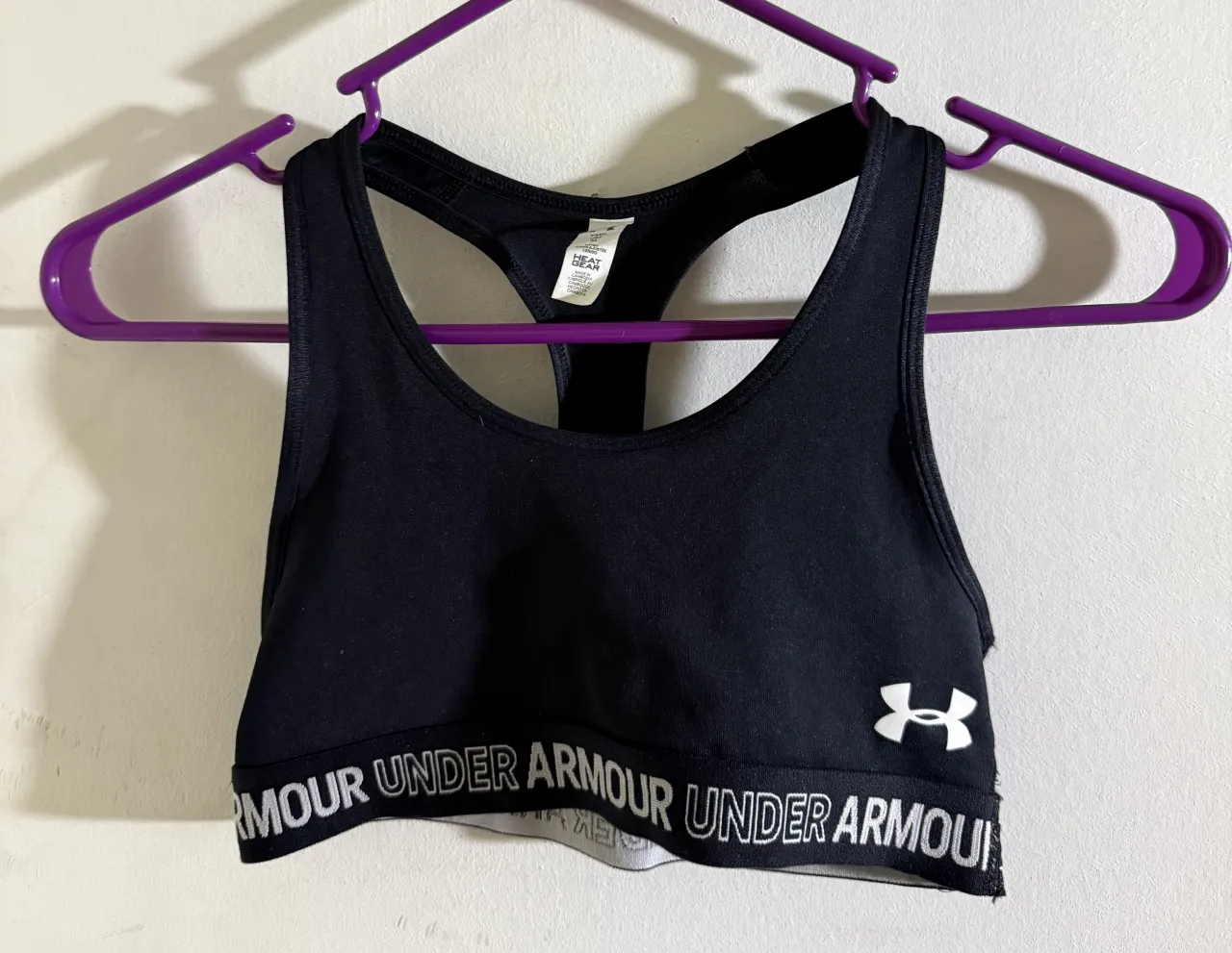 Top deportivo negro de Under Armour, ideal para entrenamientos. Posee elástico con logo de la marca en la cintura.