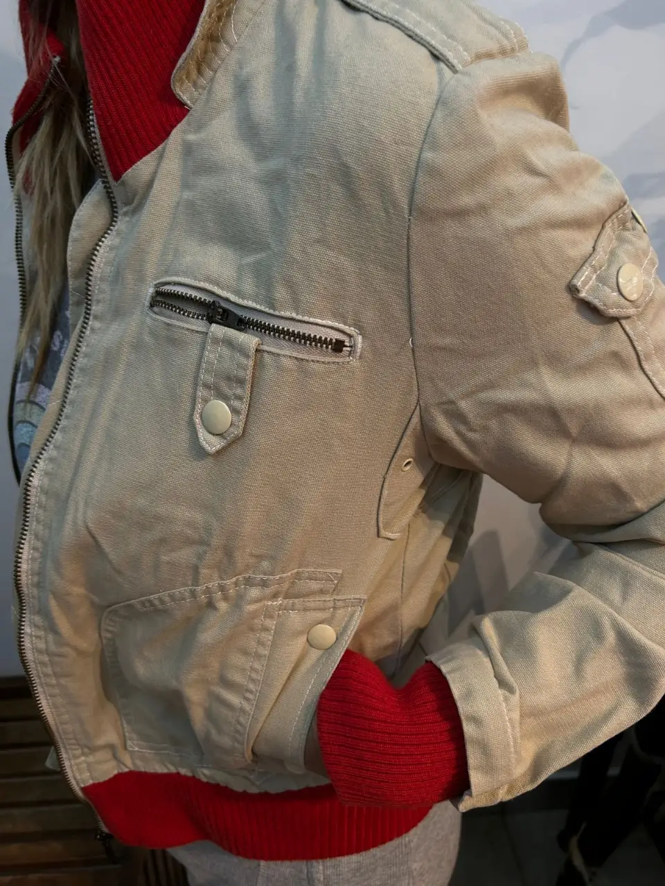 Campera Paula Cahen D Anvers bomber de color crudo con detalles en rojo. Posee bolsillos y cierre frontal. Ideal para un look casual y abrigado.