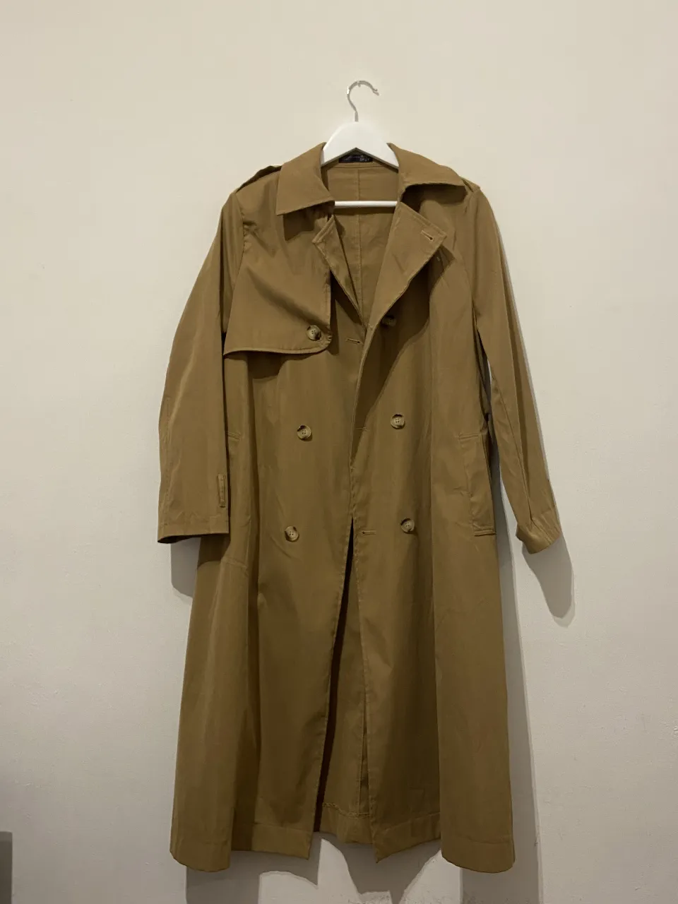 Trench coat largo color marrón, con doble botonadura y cinturón. No tiene forro. Ideal para un look elegante y sofisticado.