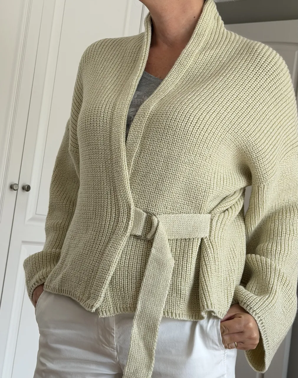 Cardigan tejido color crudo con cinturón.