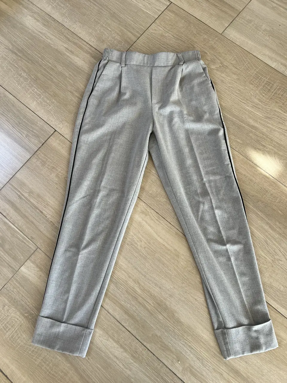 Pantalón sastrero gris de mujer, con detalle de raya negra lateral y dobladillo en el bajo. Talle S de Bershka. Ideal para un look elegante y versátil.