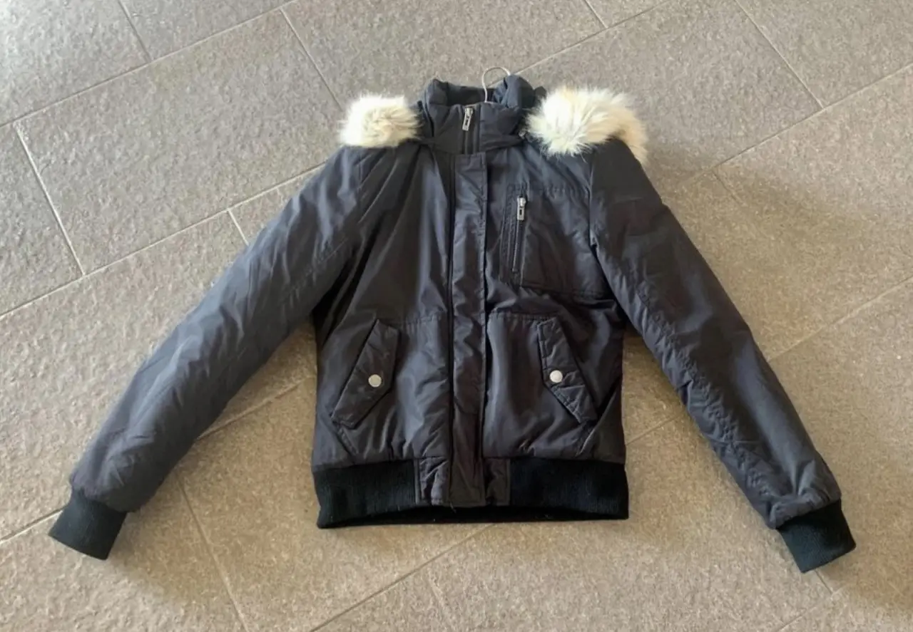 Campera bomber negra con capucha y borde de piel sintética. Ideal para el invierno, con puños y cintura tejidos. Marca Mistral, talle 1.