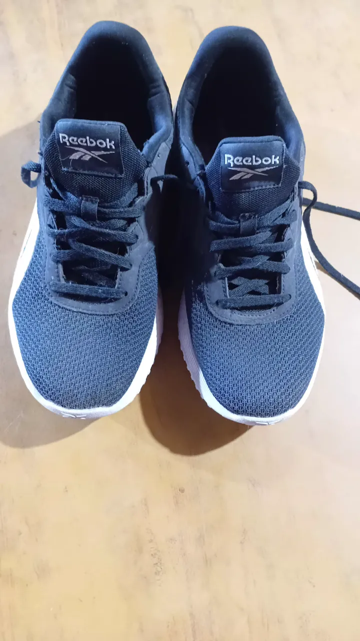 Zapatillas deportivas Reebok negras con detalles blancos. Ideales para running o entrenamiento. Cómodas y livianas.