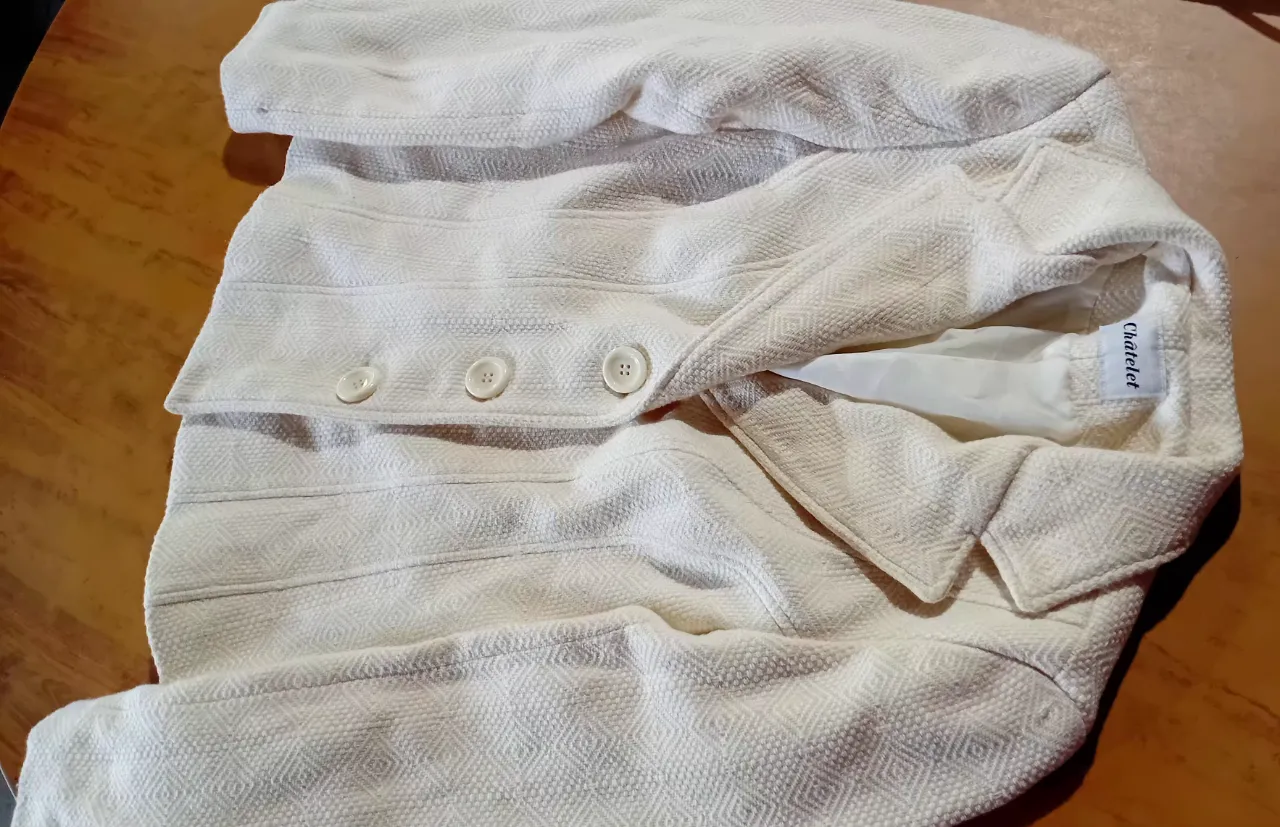 Chaqueta blanca de tela texturizada con botones al frente. Ideal para un look elegante y casual.