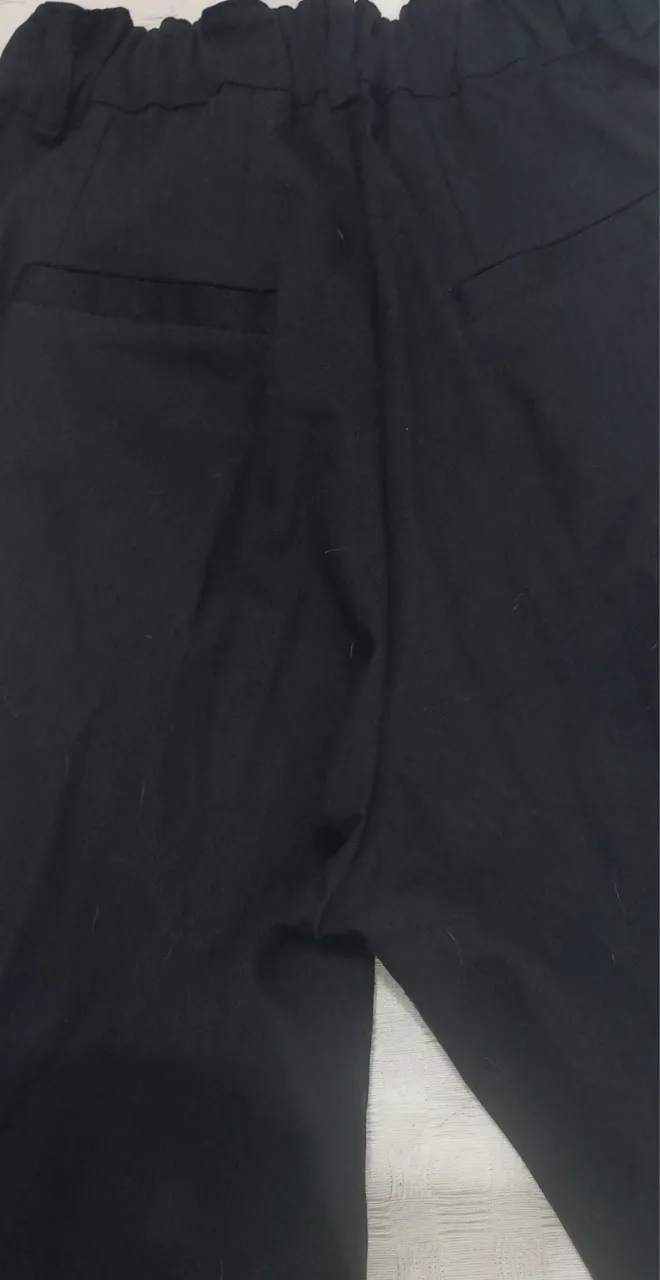 Pantalón Palazzo de Gabardina negro con cintura elastizada y bolsillos traseros. Posee un botón en la parte delantera.